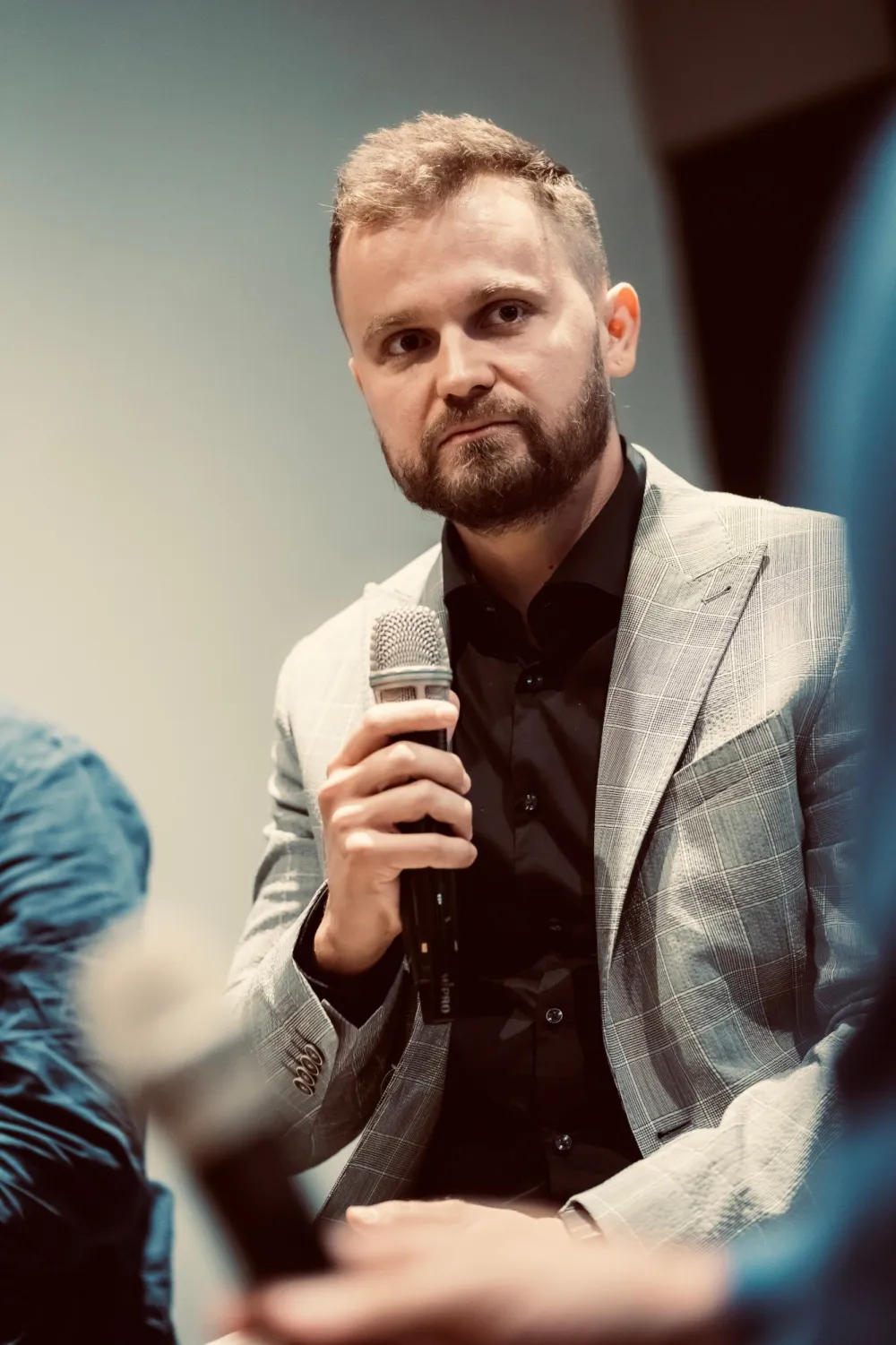 Peter Kudlej v panelovej diskusii s mikrofónom